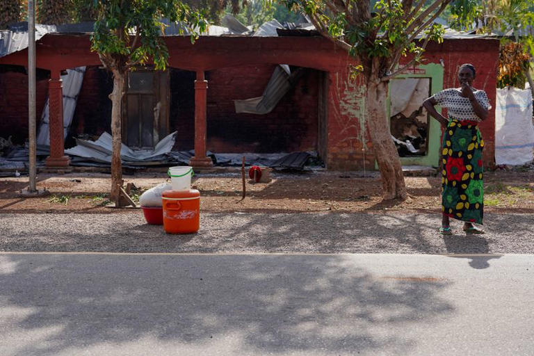 Aftermath of Yelewata attack showing burned buildings and survivors mourning