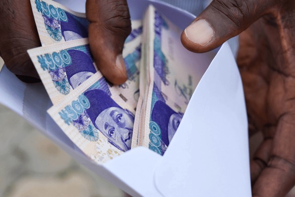 A collection of Nigerian Naira notes, symbolizing the financial cost of corruption.